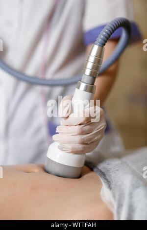 Vuoto dispositivo di massaggio . Anti Cellulite corpo trattamento di correzione. La perdita di peso apparecchio. Donna e dottore in medicina salon. Salone di bellezza. Massaggio vuoto dell'addome. Massaggio anticellulite. Foto Stock