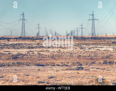 Righe della linea elettrica ad alta tensione tralicci nel deserto Foto Stock