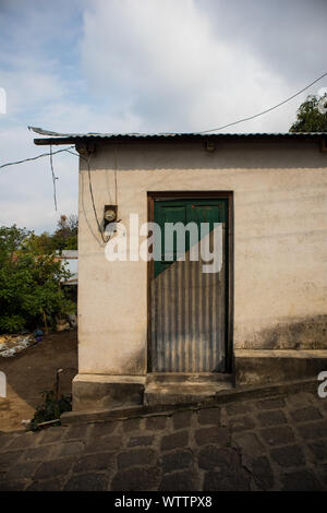 Un piccolo edificio con la porta di metà di metallo e legno verde in Guatemala Foto Stock