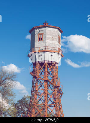 In legno antico water tower con keeper stanza sopra il cielo blu Foto Stock