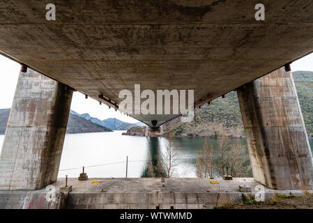 Sospensione moderno ponte attraverso il serbatoio a Los Barrios De Luna in Castiglia e Leon, Spagna. Vista da sotto il ponte Foto Stock