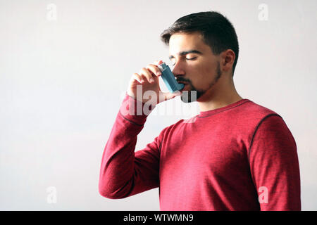 Salute e medicina - Giovane utilizzando blu asma inalatore per impedire un attacco d'asma. Prodotto farmaceutico per la prevenzione e il trattamento di asma. Foto Stock