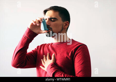 Salute e medicina - Giovane utilizzando blu asma inalatore per impedire un attacco d'asma. Prodotto farmaceutico per la prevenzione e il trattamento di asma. Foto Stock