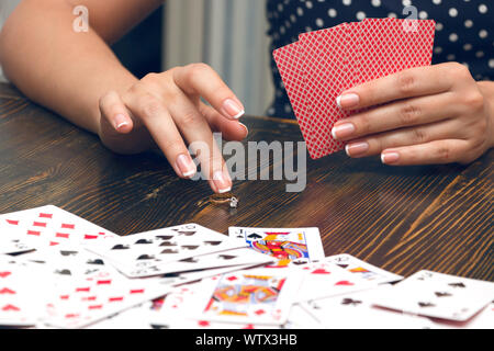 Donna mette come una scommessa con il suo golden ring in una partita di poker Foto Stock
