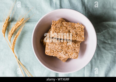 Barrette di cereali nella tazza colazione con spighe di grano accanto ad essa - vista superiore foto Foto Stock