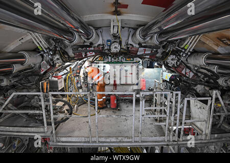 Un ingegnere lavora alla estremità anteriore di una macchina alesatrice lo scavo di una sezione della Thames Tideway Tunnel in Londra. Foto Stock