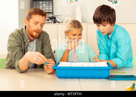 Insegnante di scienze dare un compito ai suoi alunni. Foto Stock