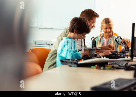 Ragazzo e una ragazza la costruzione di robot al loro lezione di scienze. Foto Stock