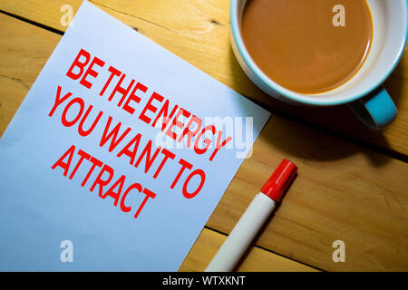 Essere l'energia che si desidera attirare il testo sulla carta isolato su sfondo tabella Foto Stock