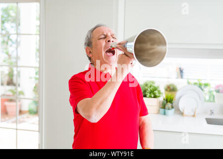 Senior shouthing uomo eccitato attraverso il metallo vintage megafono Foto Stock