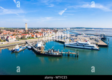 Paesi Bassi, Terschelling - Agosto 25, 2019: Brandaris torri faro verso l'alto. Catamarano MS Tiger attraccata ad una banchina e altre navi lungo i pontili in h Foto Stock