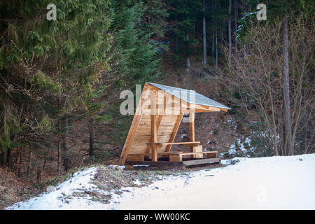 Gazebo in legno nel bosco innevato Foto Stock