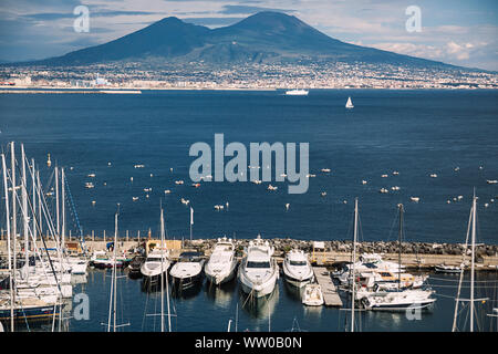 Paesaggio urbano di Napoli. Vulcano Vesuvio in nuvole. Vulcano e paesaggio marino. Concetto di viaggio. Paesaggio aereo italiano. Italia, Campania. Barche e barca a vela. Foto Stock