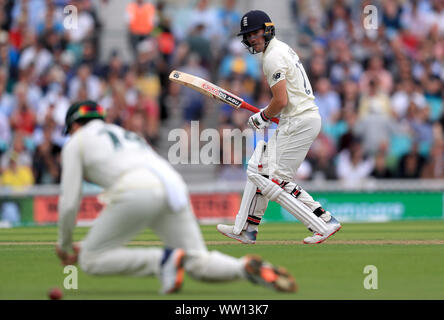 L'Inghilterra del Rory Burns guarda come Australia Marcus Harris fumbles la sfera come egli campi durante il primo giorno della quinta prova corrisponde al ovale, Londra. Foto Stock
