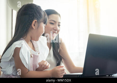 Bella asiatica madre e figlia che lavora insieme a casa ufficio dalla finestra. Nel concetto di mamma single o genitore single. Foto Stock