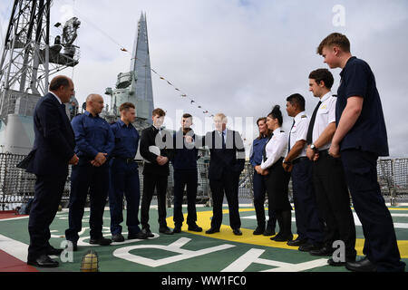 Il primo ministro Boris Johnson accompagnato dal segretario alla difesa Ben Wallace (sinistra) come egli visiti la NLV Pharos, un faro gara ormeggiato sul fiume Tamigi per contrassegnare London International Settimana di spedizione. Foto di PA. Picture Data: giovedì 12 settembre, 2019. Foto di credito dovrebbe leggere: Daniel Leal-Olivas/PA FILO Foto Stock