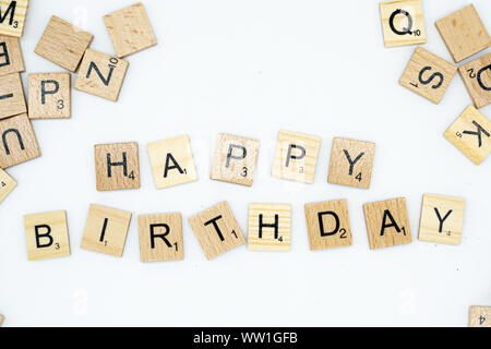 Chiudere dettagliata di buon compleanno farro in lettere di legno su sfondo bianco Foto Stock