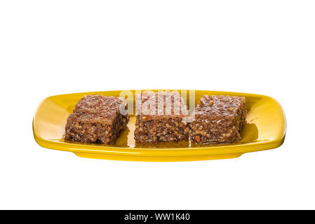 Pezzi di Sheki halva su una piastra isolata su bianco Foto Stock