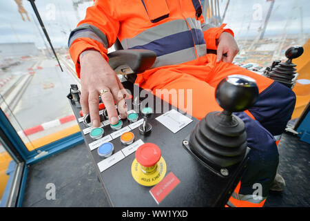 Il gruista Martin Redmond aziona pulsanti dentro la sua cabina a bordo di "Big Carl', il più grande del mondo di gru che si appresta ad iniziare i lavori a Hinkley Point C power station in Somerset. In grado di sopportare fino a 250m di altezza, il Sarens SCC-250 gru può raggiungere maggiore del più alto tower presso il London Canary Wharf e può trasportare 5.000 tonnellate in un ascensore singolo. Foto Stock