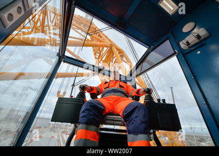 Il gruista Martin Redmond dentro la sua cabina a bordo di "Big Carl', il più grande del mondo di gru che si appresta ad iniziare i lavori a Hinkley Point C power station in Somerset. In grado di sopportare fino a 250m di altezza, il Sarens SCC-250 gru può raggiungere maggiore del più alto tower presso il London Canary Wharf e può trasportare 5.000 tonnellate in un ascensore singolo. Foto Stock