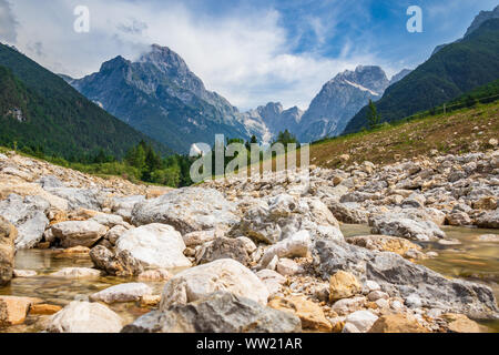 Fiume Predelica vicino a molla con la montagna Mangart-Jalovec massiccia nelle Alpi Giulie all'interno del bellissimo paesaggio. Log pod Mangartom, Bovec, Slovenia Foto Stock