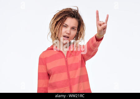 Giovane donna asiatica con dreadlocks mostra un segno di roccia. Studio shot Foto Stock