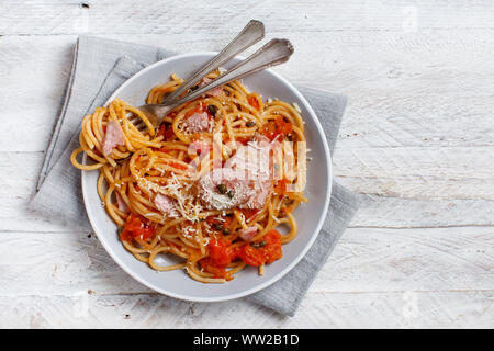Spaghetti con i pezzi di tonno fresco, pomodoro e capperi close up Foto Stock