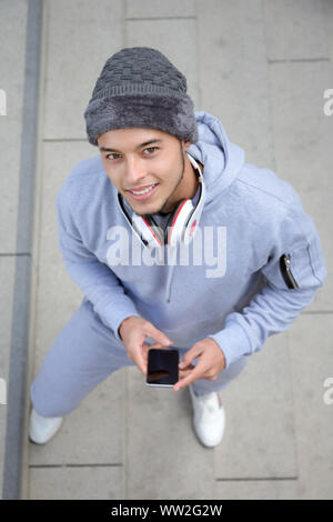 Sorridente giovane uomo latino runner formato ritratto sport invernali dalla formazione esterna di cui sopra Foto Stock