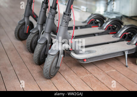 Scooter elettrici parcheggiato in modo ordinato in una area di parcheggio. Foto Stock