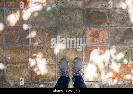 Vista dall'alto di grigio sneakers in piedi sul pavimento di cemento con copia spazio. Foto Stock