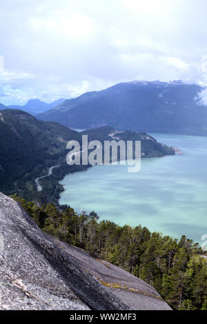 Una visione chiara di turchese Howe Sound bay e Highway 99 passando attraverso le montagne litoranee e foresta, su una escursione a Capo Stawamus parco provinciale Foto Stock