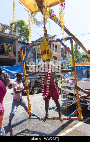 Pussellawa, Sri Lanka, 03/20/2019: festival indù di Thaipusam - body piercing rituali sotto la luna di sangue. L'uomo appeso a pelle. Foto Stock