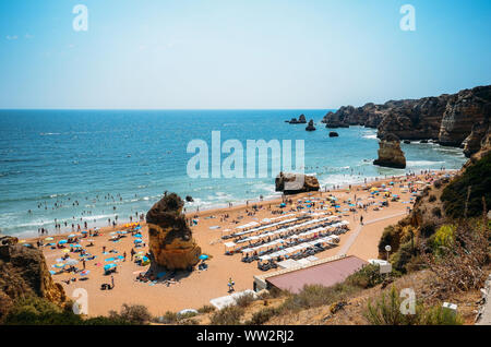 Alta vista prospettica di beachgoers a Cova Redonda spiaggia di Algarve, Portogallo meridionale in un giorno d'estate. Foto Stock