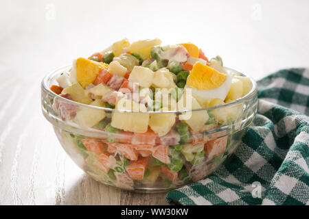 Tradizionale insalata russa per il Natale. Insalata di Olivier sul tavolo di legno Foto Stock