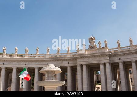 Vista del paesaggio di colonne, statue e una bandiera italiana sventolare in piazza San Pietro, Roma, Italia su una soleggiata giornata estiva. Copia dello spazio per aggiungere il testo abo Foto Stock