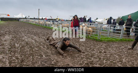 Kendal, Cumbria, Regno Unito. Xii Sep 2019. Le condizioni meteo didnt smorzare gli spiriti di tutti l'Westmorland County show, Kendal Cumbria, come questo fanciullo ha dimostrato, godendo di una diapositiva di fango. Non è certo che i suoi genitori ci è piaciuto tanto quanto ha fatto! Credito: Wayne HUTCHINSON/Alamy Live News Foto Stock