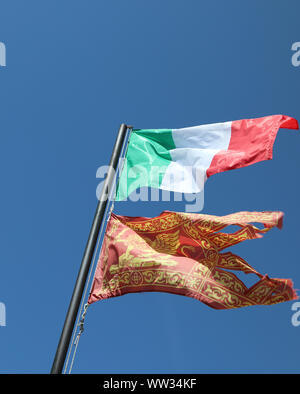 Bandiera Italiana e bandiera veneziana sul cielo blu Foto Stock