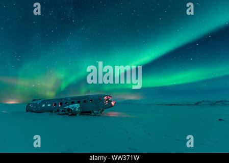 L'aurora boreale sul relitto aereo in Islanda Foto Stock