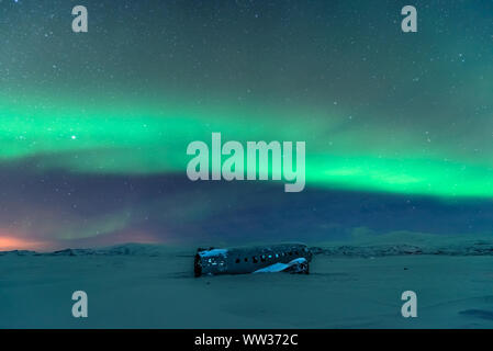 L'aurora boreale sul relitto aereo in Islanda Foto Stock