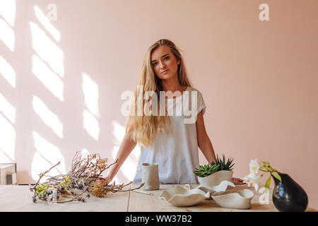 Ritratto di giovane donna ceramista in piedi nel suo studio Foto Stock