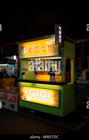 Taipei, Taiwan: piccola strada stallo alimentare venditore a vendere una varietà di frutta fresca bevande al latte al Mercato Notturno di Raohe Foto Stock