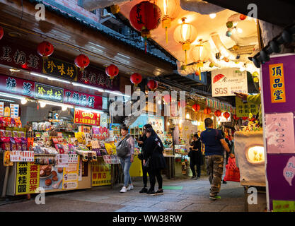 Jiufen old street con i turisti a passeggiare e a fare shopping. Cinese tradizionale lanterne appese lungo la strada stretta. Foto Stock