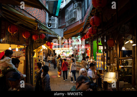 Jiufen old street con i turisti a passeggiare e a fare shopping. Cinese tradizionale lanterne appese lungo la strada stretta. Foto Stock