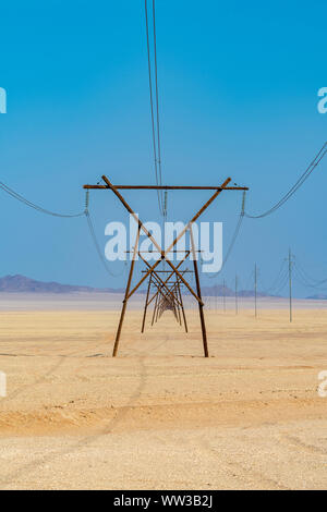 I pali dell'elettricità in una fila nel deserto, Namibia Foto Stock
