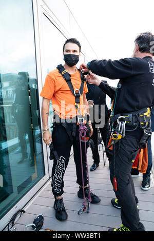 L'artista di strada Alec Monoploy abseils giù la flanelle store su Oxford Street, Londra in occasione della celebrazione del suo lancio di apertura. Foto Stock