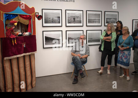 Martin Parr fotografo ( seduti ) a Martin Parr Fondazione galleria MPF Bristol. Mostra lavori da Marketa Luskacova 2010s 2019 HOMER SYKES Foto Stock