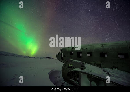 Luci del nord al disopra del piano relitto in Islanda Foto Stock