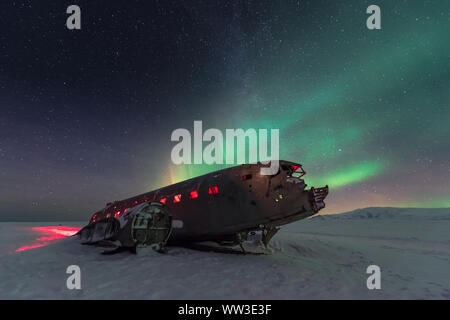 Luci del nord al disopra del piano relitto in Islanda Foto Stock