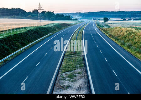 Svuotare strada a due corsie che si estende fino all'orizzonte Foto Stock