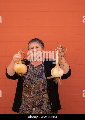 Vecchia donna mostra il suo cresciuto in casa le cipolle, Galizia, Spagna Foto Stock